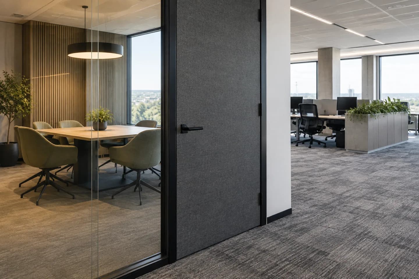 Glazed meeting-room threshold beside a carpeted workplace