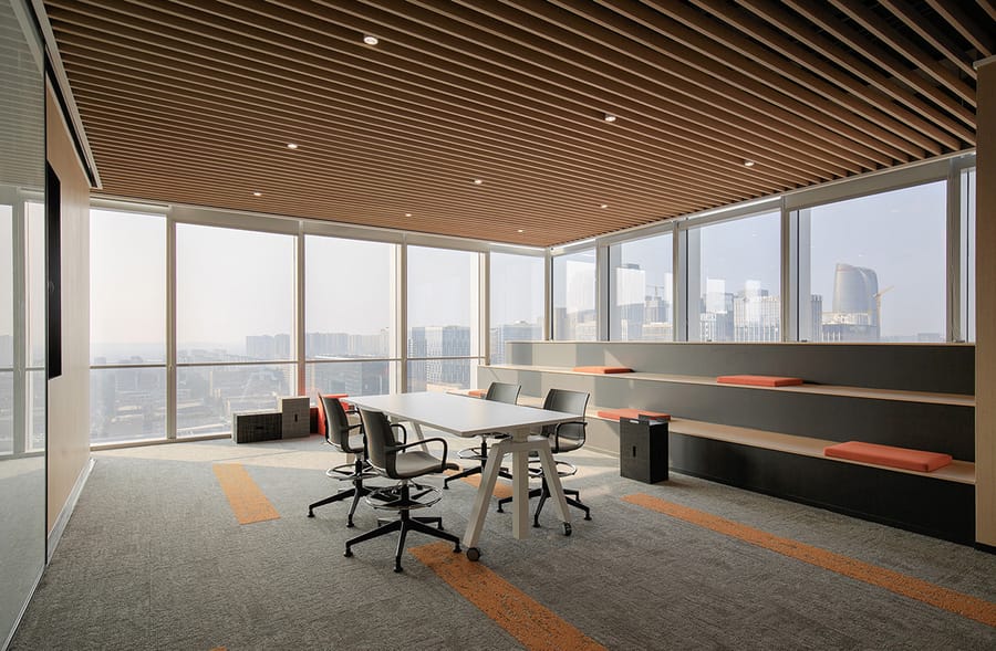 Meeting room with slatted timber acoustic ceiling above carpet tile and full-height glazing