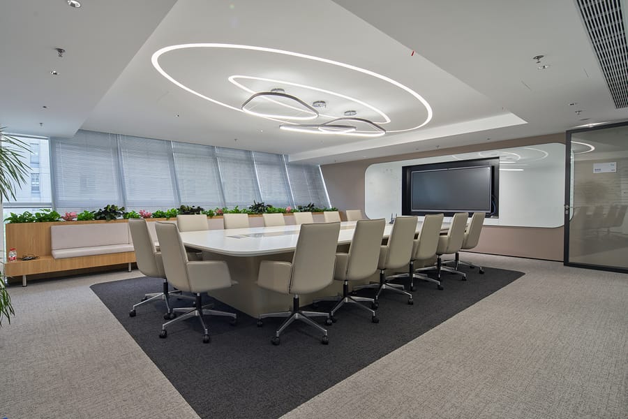 UNIJOY carpet tile in a bright office meeting space, used as verified visual context for a public-interior brief